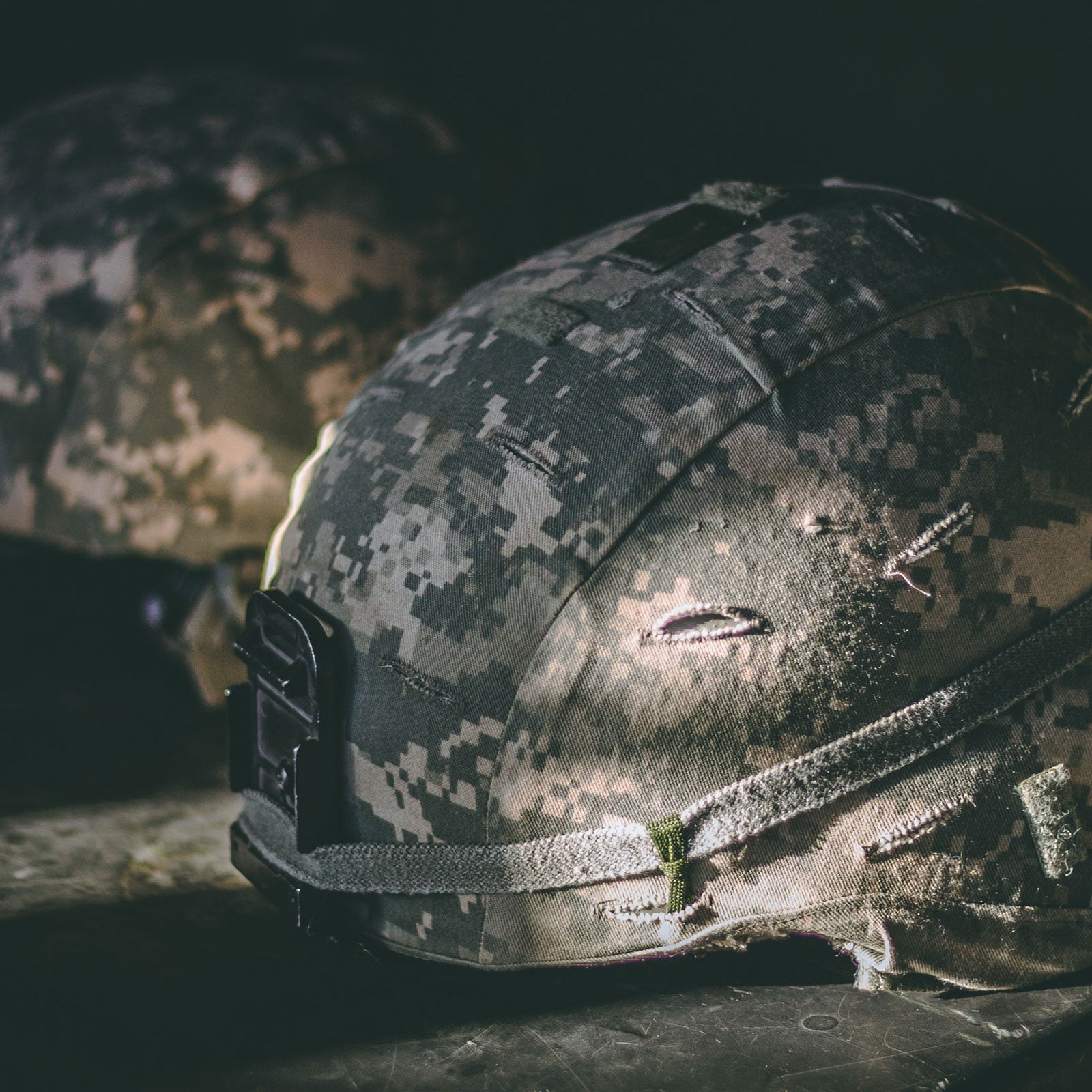 Two desert fatigue helmets resting on a military case.