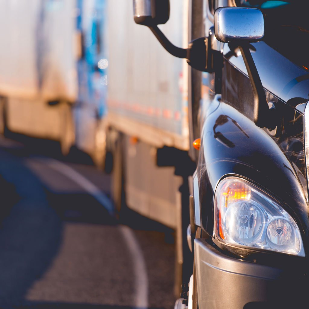 A line of semi-trucks stuck in traffic.
