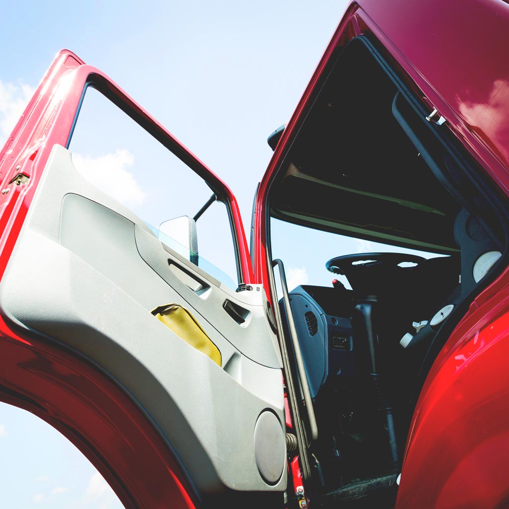 Photo of a high-cab semi truck from the ground indicating a fall and injury has occurred